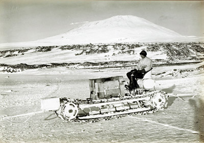 Bernard Day ona a motor sledge in front of Mount Erebus